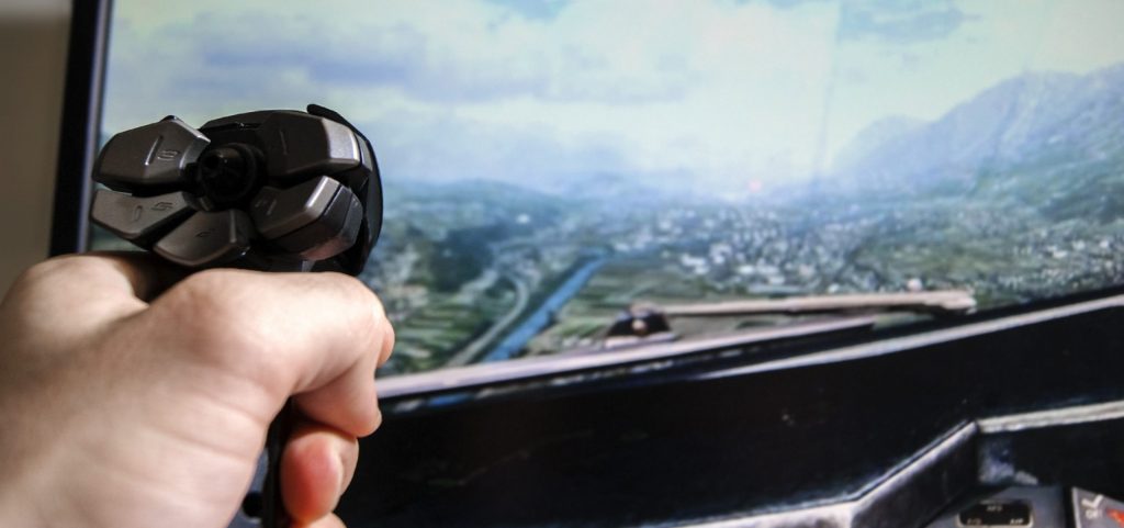 Someone using a joystick to fly a home flight simulator.