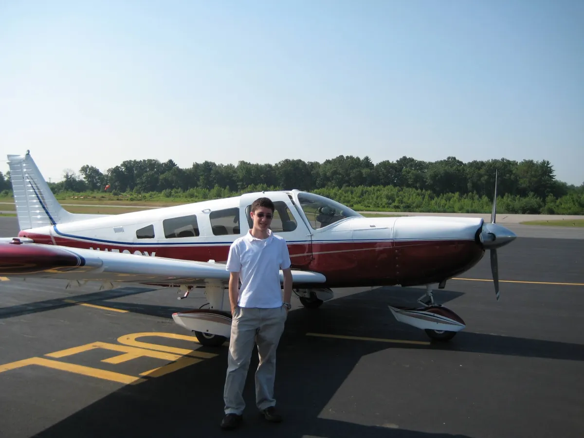 Student pilot standing next to a Piper aircraft for a discovery flight